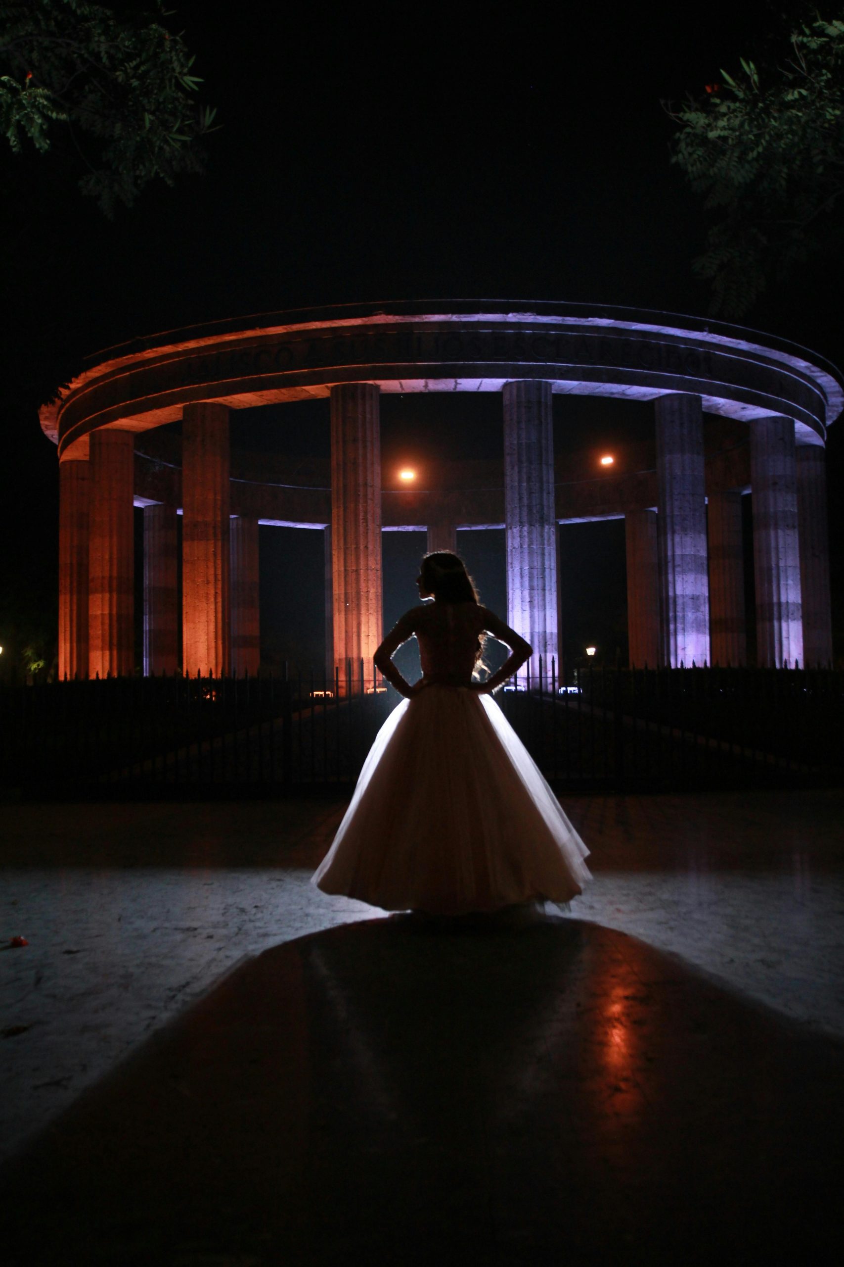 Photo showcasing prom dresses trends 2024: A girl stands elegantly in a grand ball gown, surrounded by the timeless beauty of a castle backdrop.